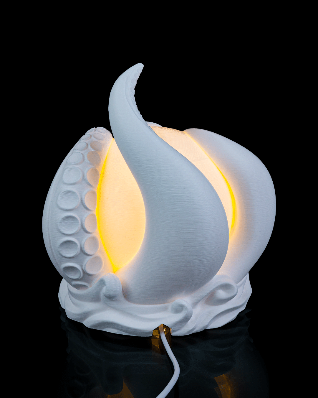 White ceramic lamp shaped like a stylized flower or leaf with a glowing interior on a black background.