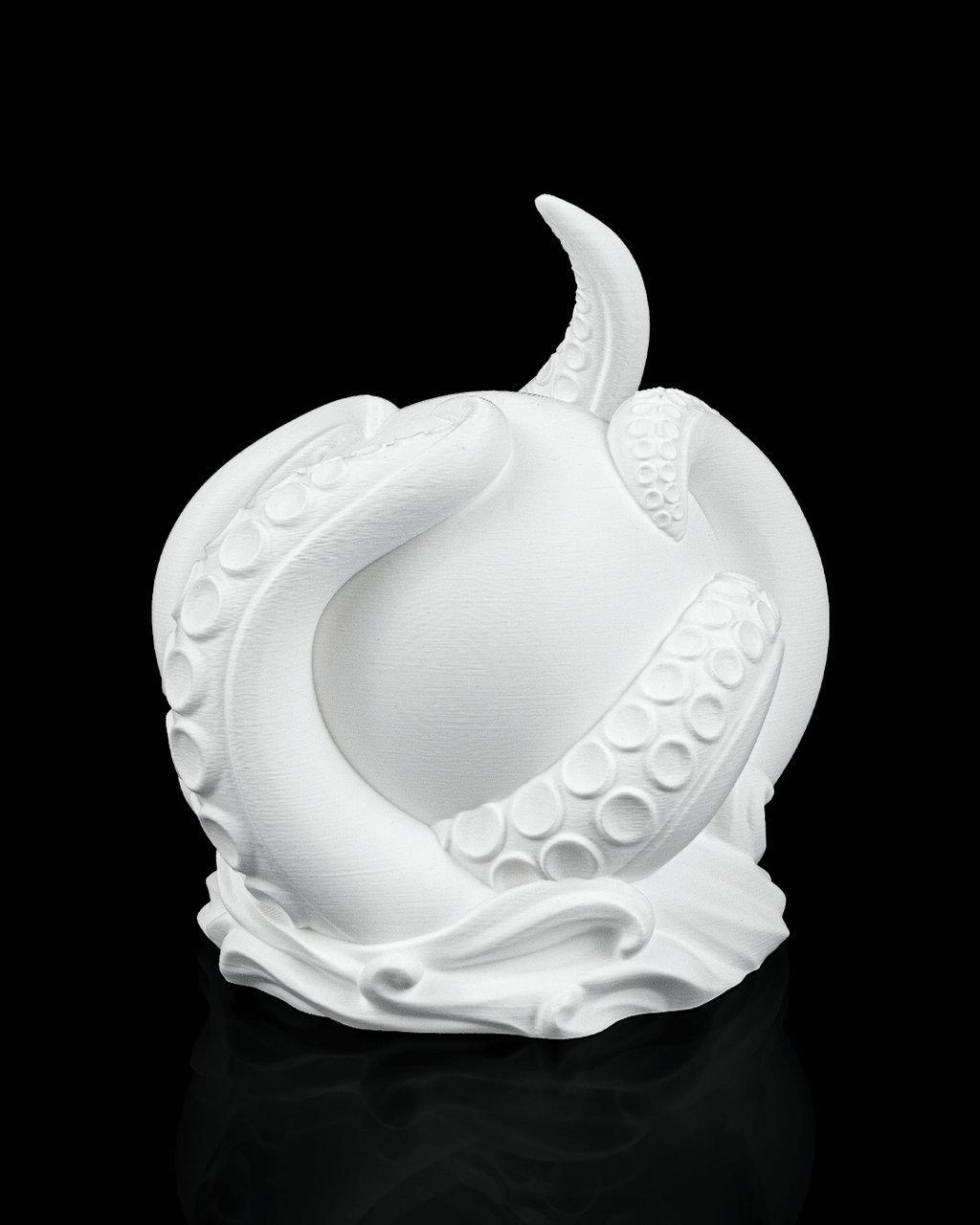 White ceramic sculpture of a stylized fruit on a black background