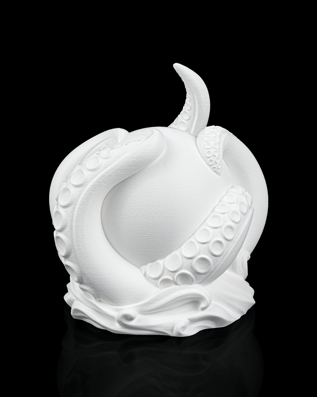 White ceramic sculpture of a stylized fruit on a black background