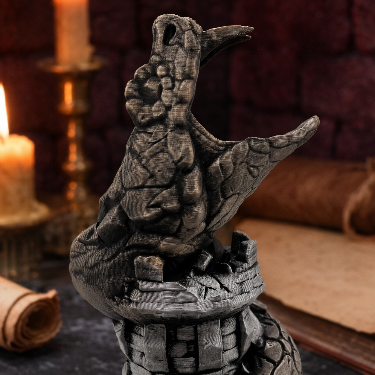A dark gray serpent figurine with its wings spread, perched on a stone-like pedestal. The background is a dimly lit, atmospheric scene with a burning candle, parchment, and a dark brick wall.