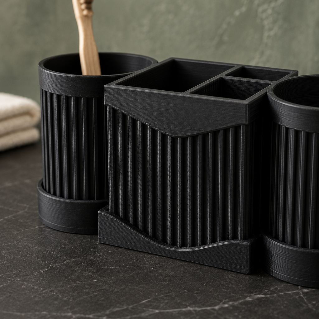 Three-piece black ribbed bathroom organizer set including two toothbrush holders and one multi-compartment tray, arranged on a dark marble countertop with a folded towel and green wall in the background.
