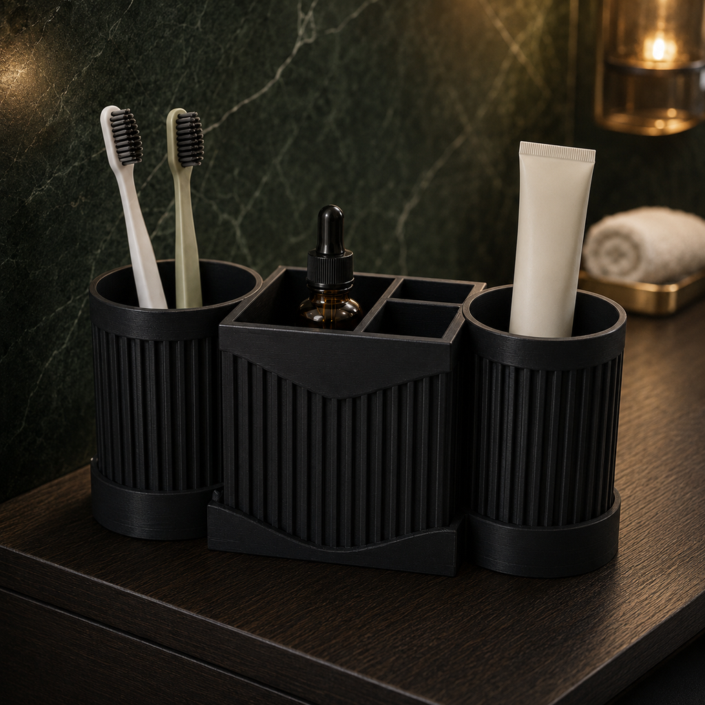 A black bathroom toothbrush holder set with three ribbed cups and a central organizer tray holding a small dropper bottle, shown on a dark wooden surface against a green marble wall.