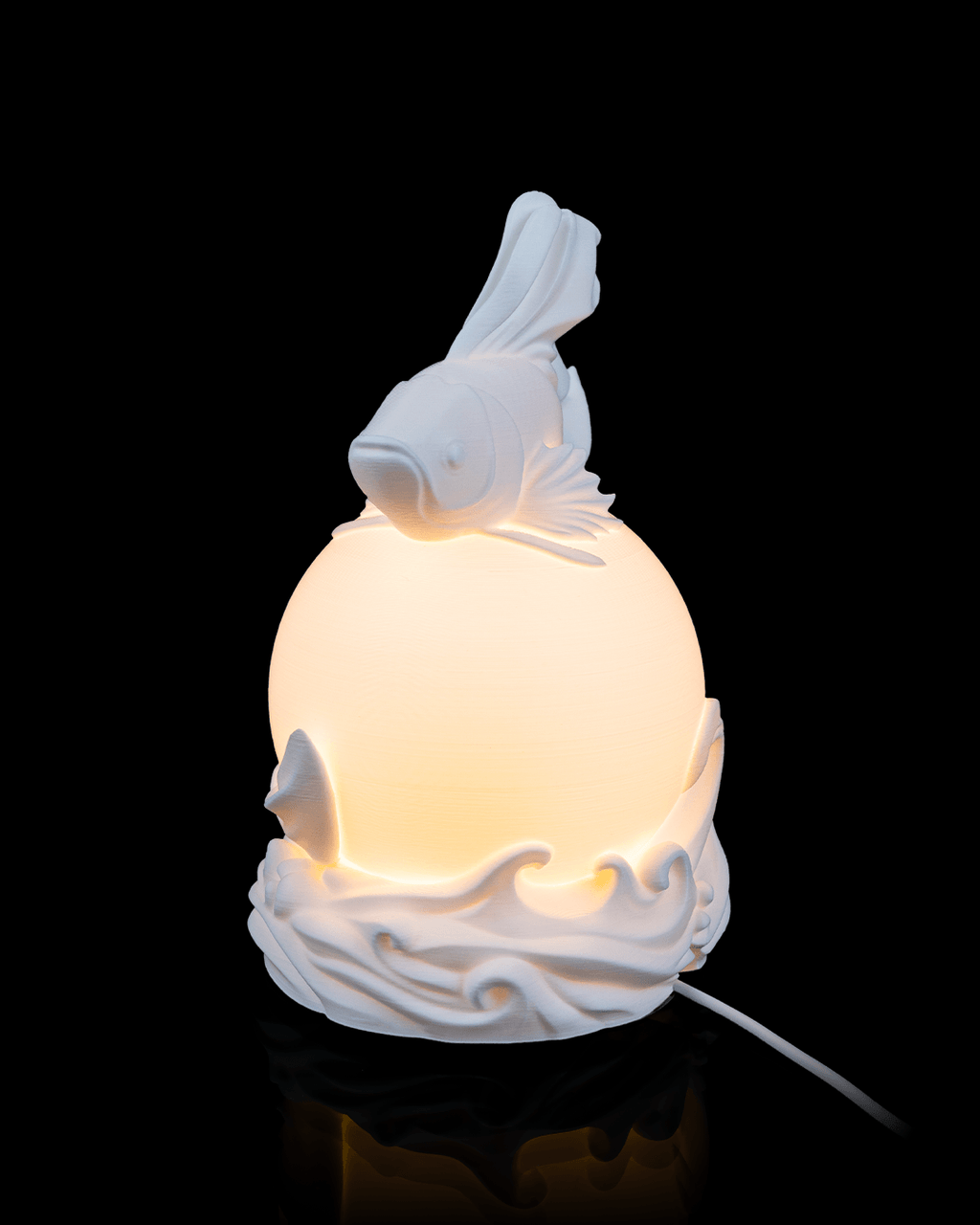White ceramic lamp with fish design on a black background