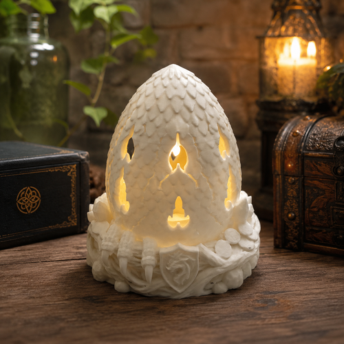 White 3D printed Dragon Egg Fairy Lamp glowing on a fantasy-themed wooden table.