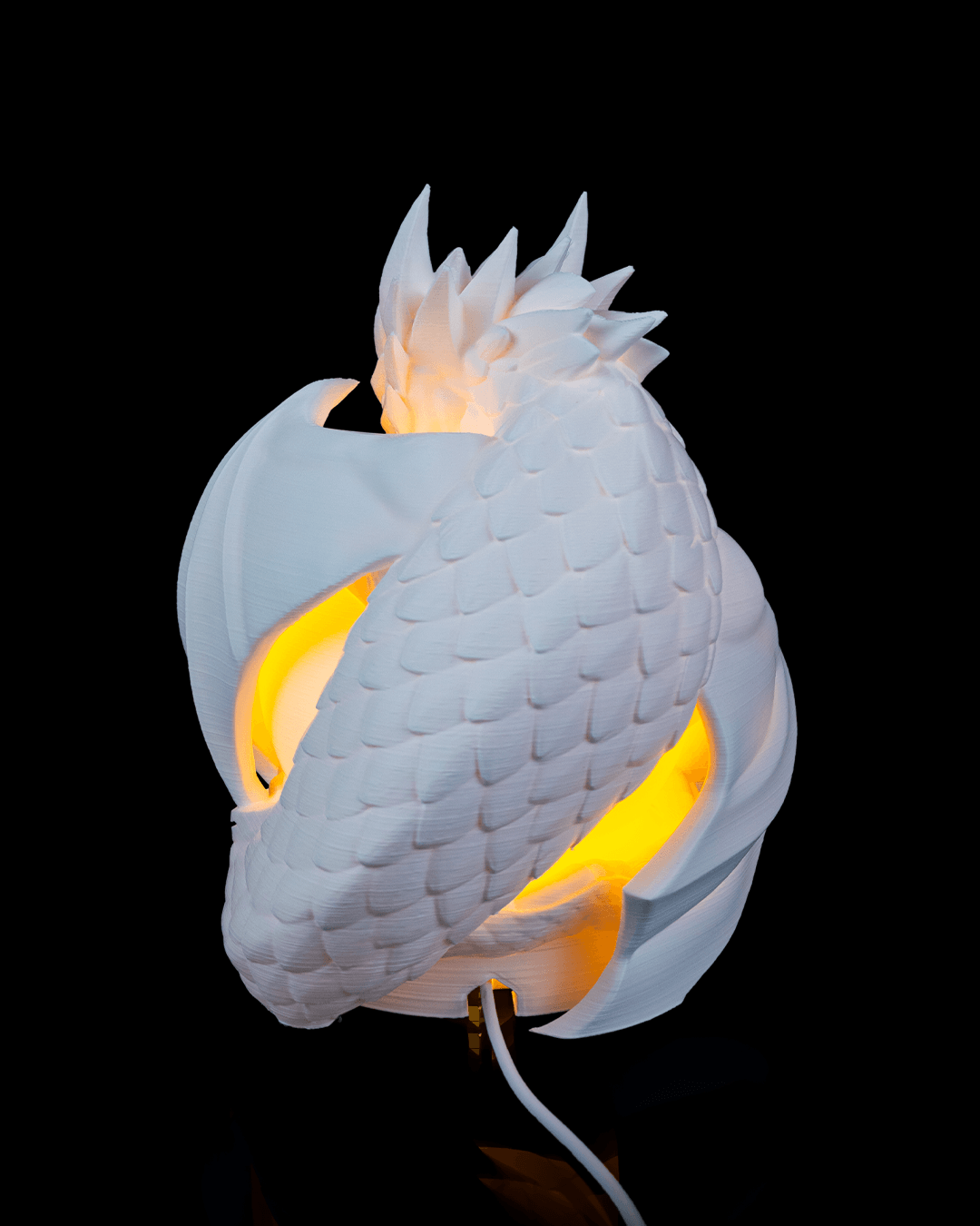 Dragon-shaped wall lamp with glowing interior on a black background