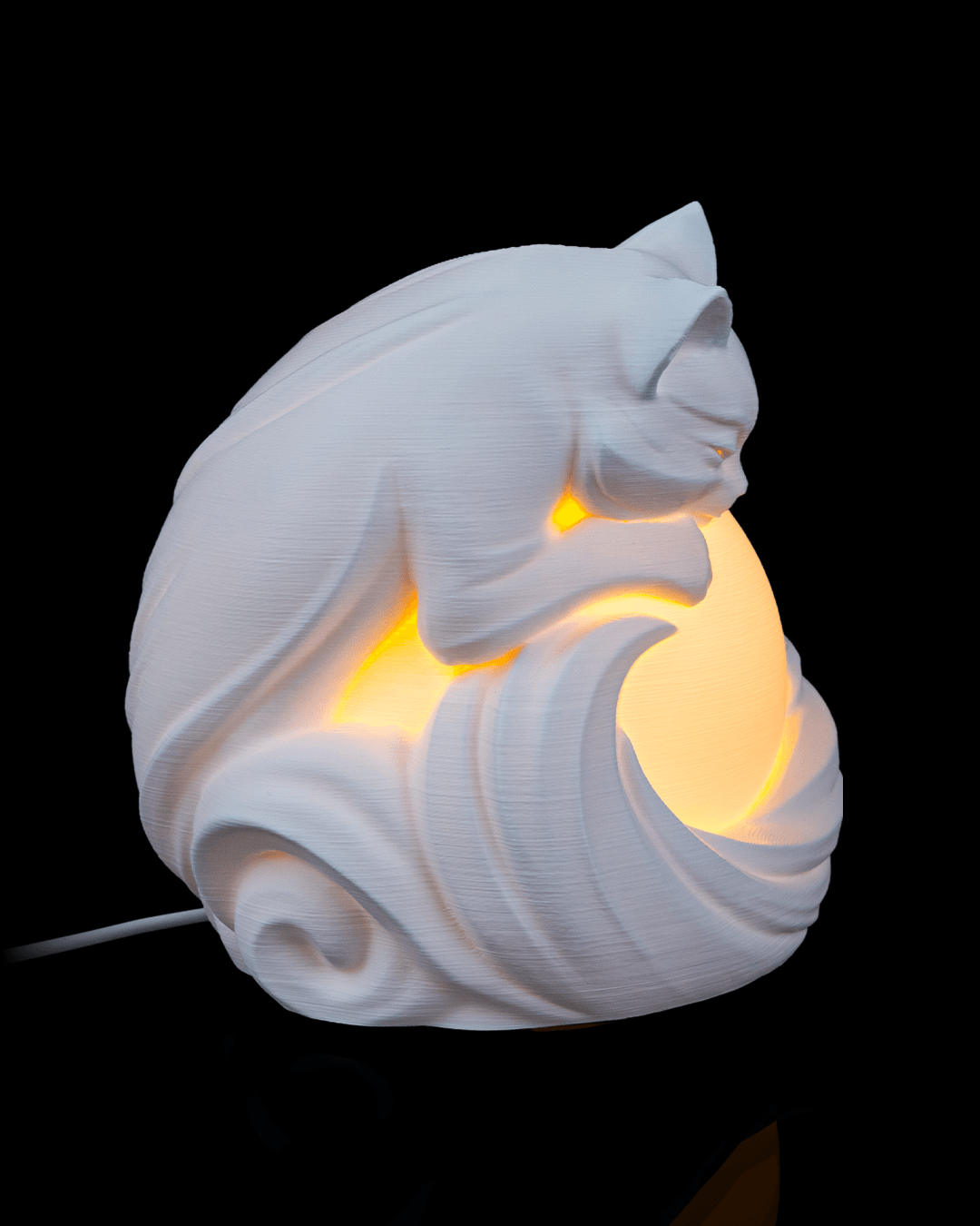 White cat-shaped lamp with a warm glow on a black background