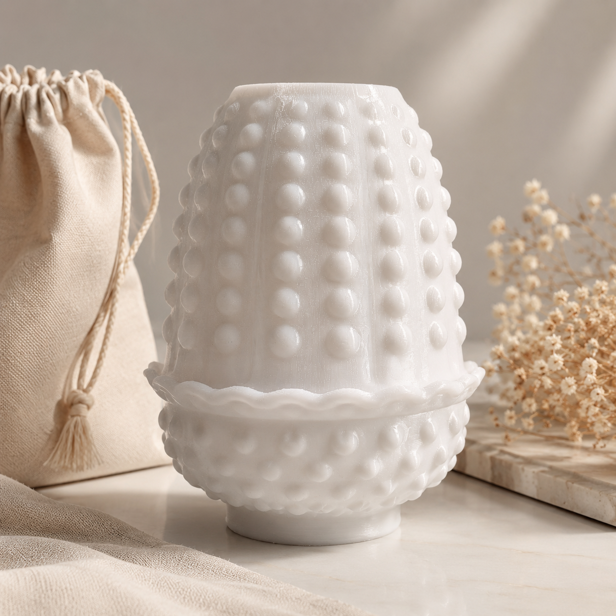 White vintage-inspired hobnail fairy lamp with scalloped rim displayed on a light wood surface with soft neutral décor and dried flowers.