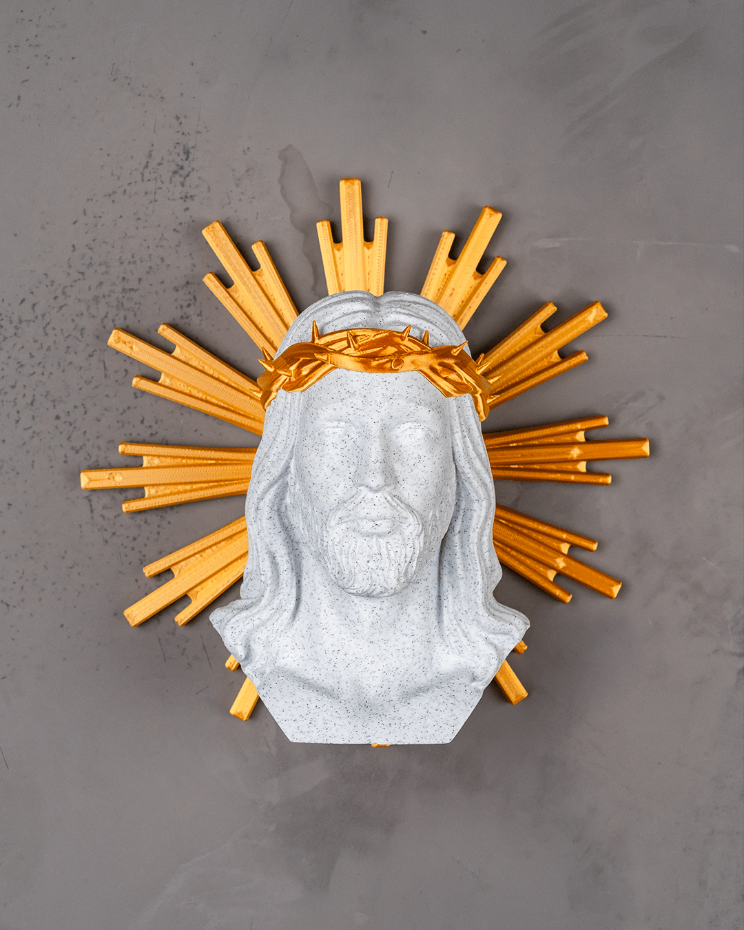 Decorative wall piece with a bust of a bearded figure and gold sunburst on a gray background