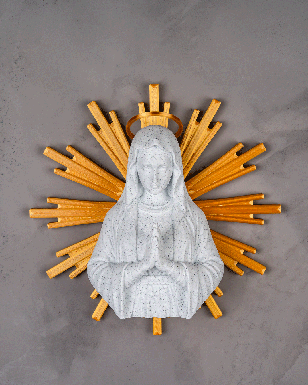 Statue of a religious figure with a wooden sunburst design on a gray background