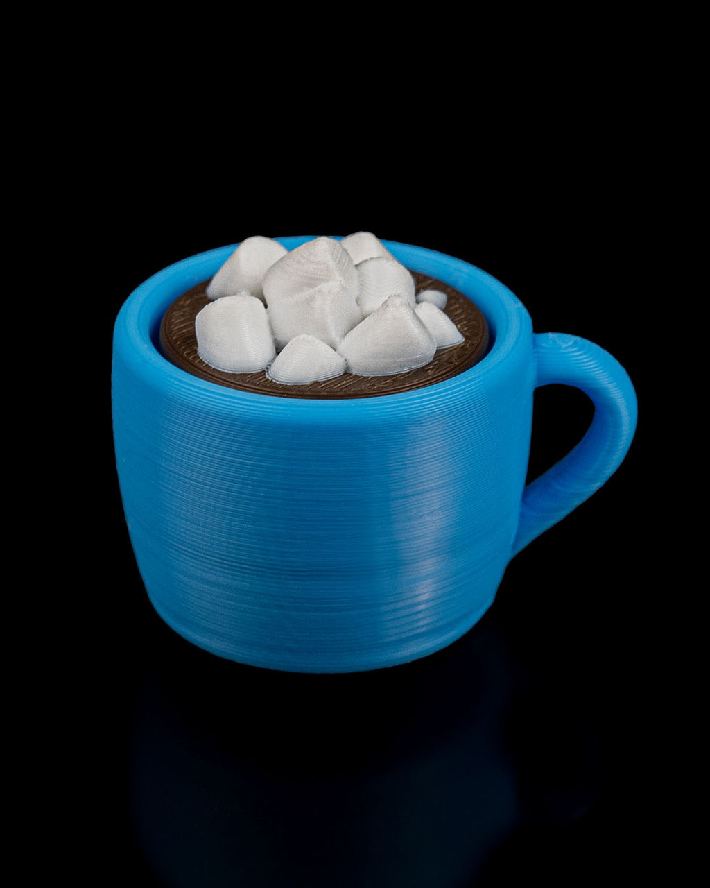 Blue mug with hot chocolate and marshmallows on a black background