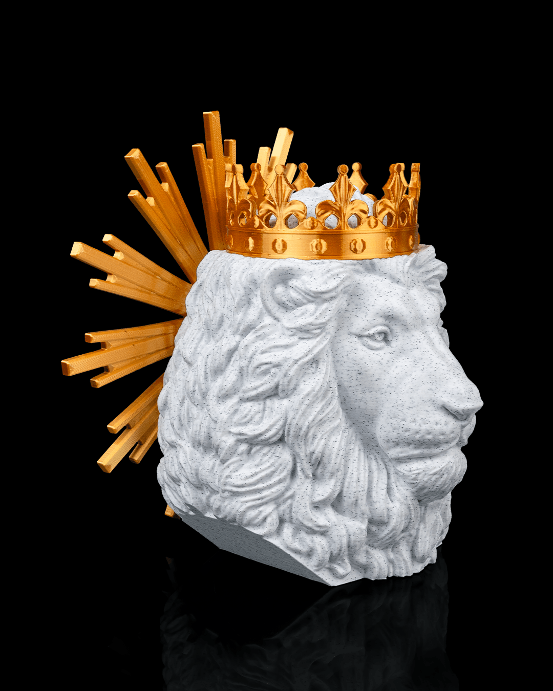 Lion head sculpture wearing a gold crown on a black background