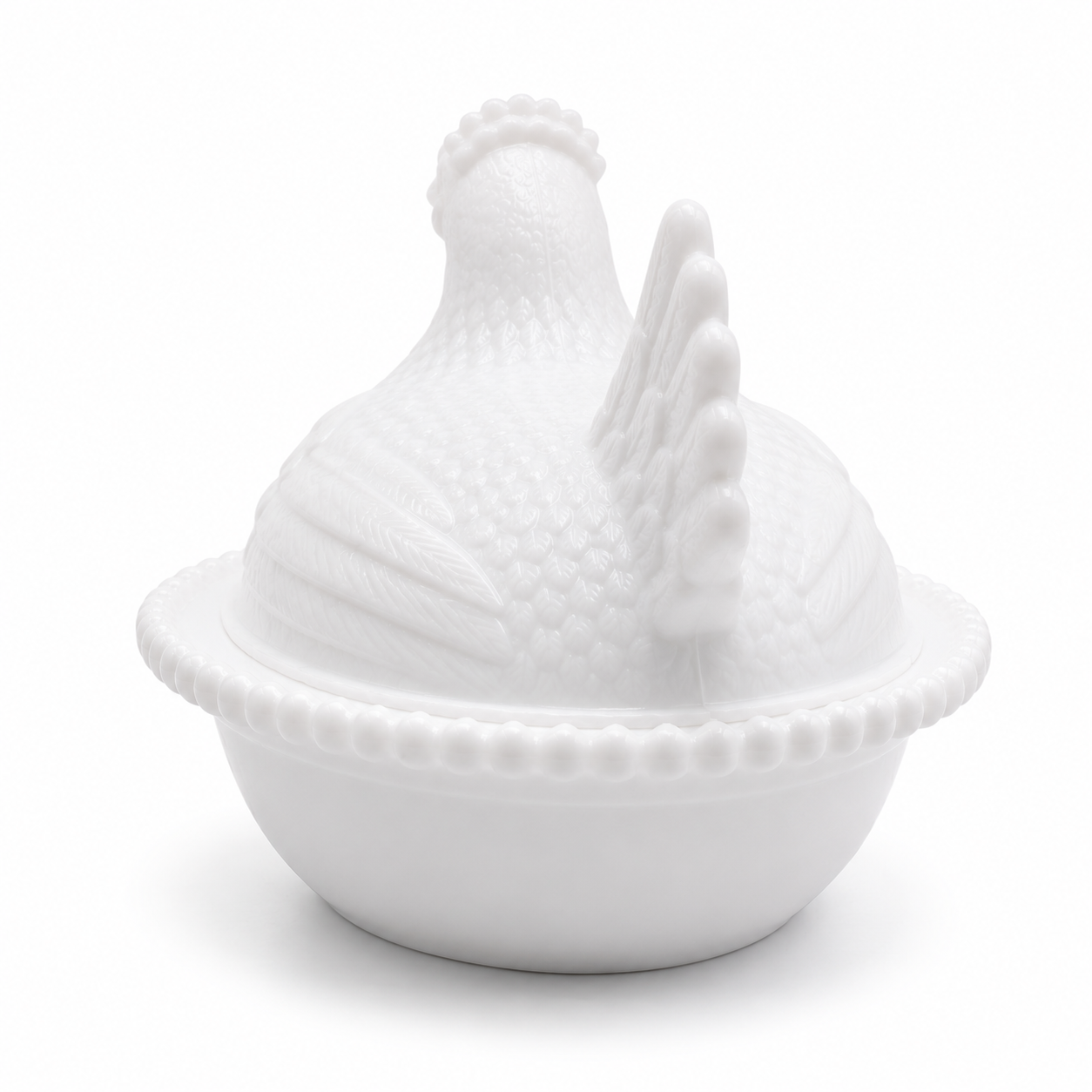 Rear view of the white hen on nest dish highlighting sculpted tail and feather details.