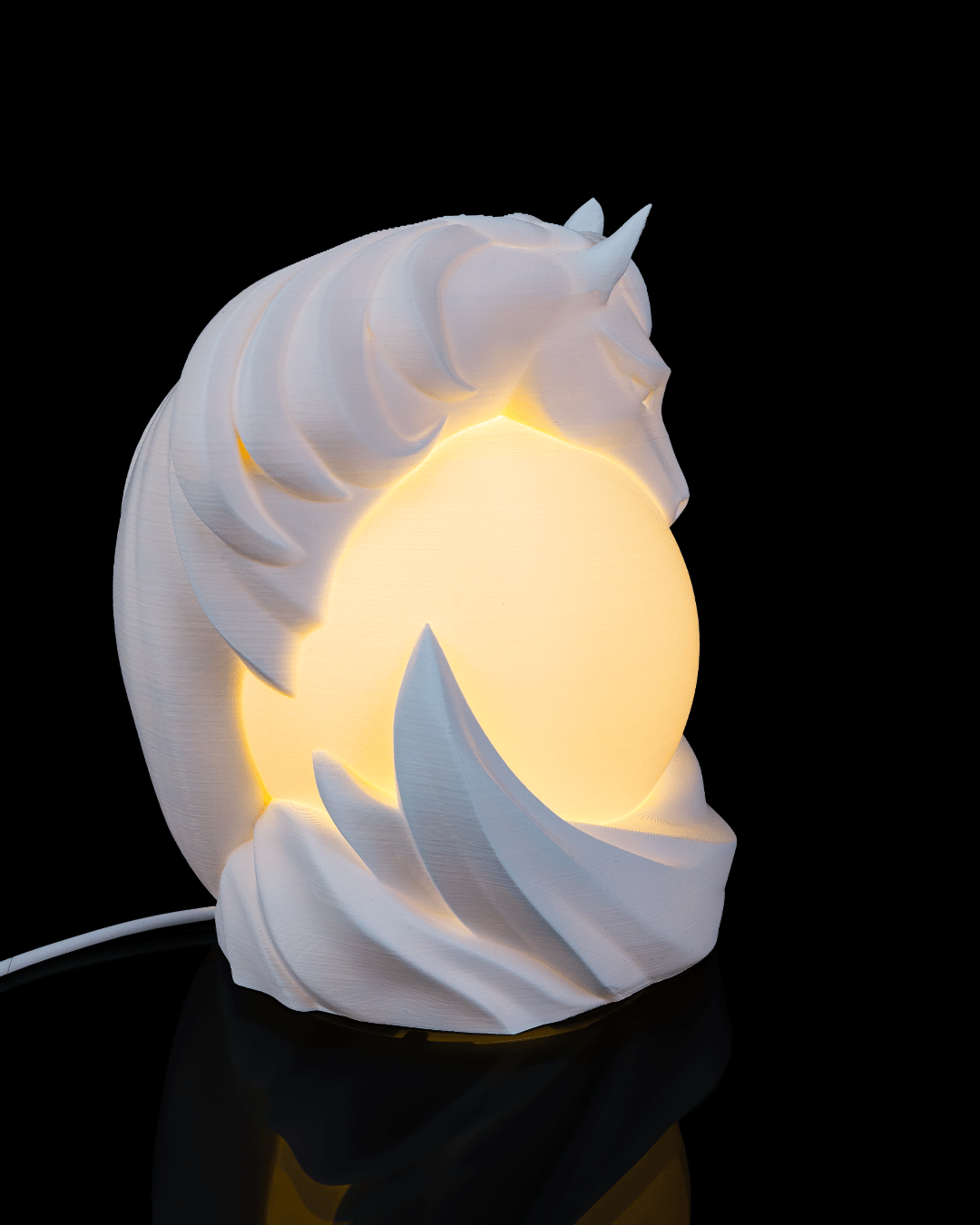 Unicorn-shaped night light with a warm glow on a black background