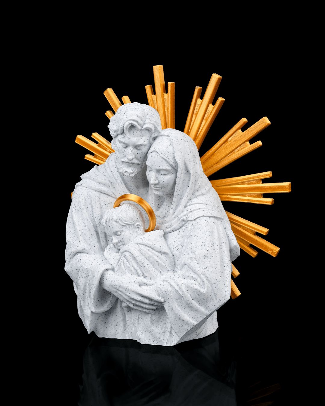 Statue of a man and woman holding a child with a gold halo against a black background