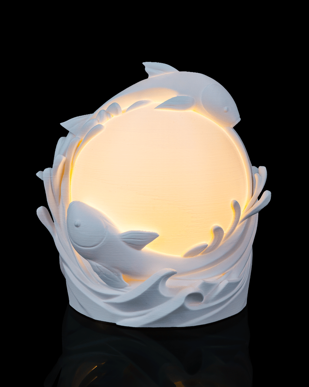 Decorative lamp with dolphins and a glowing interior on a black background