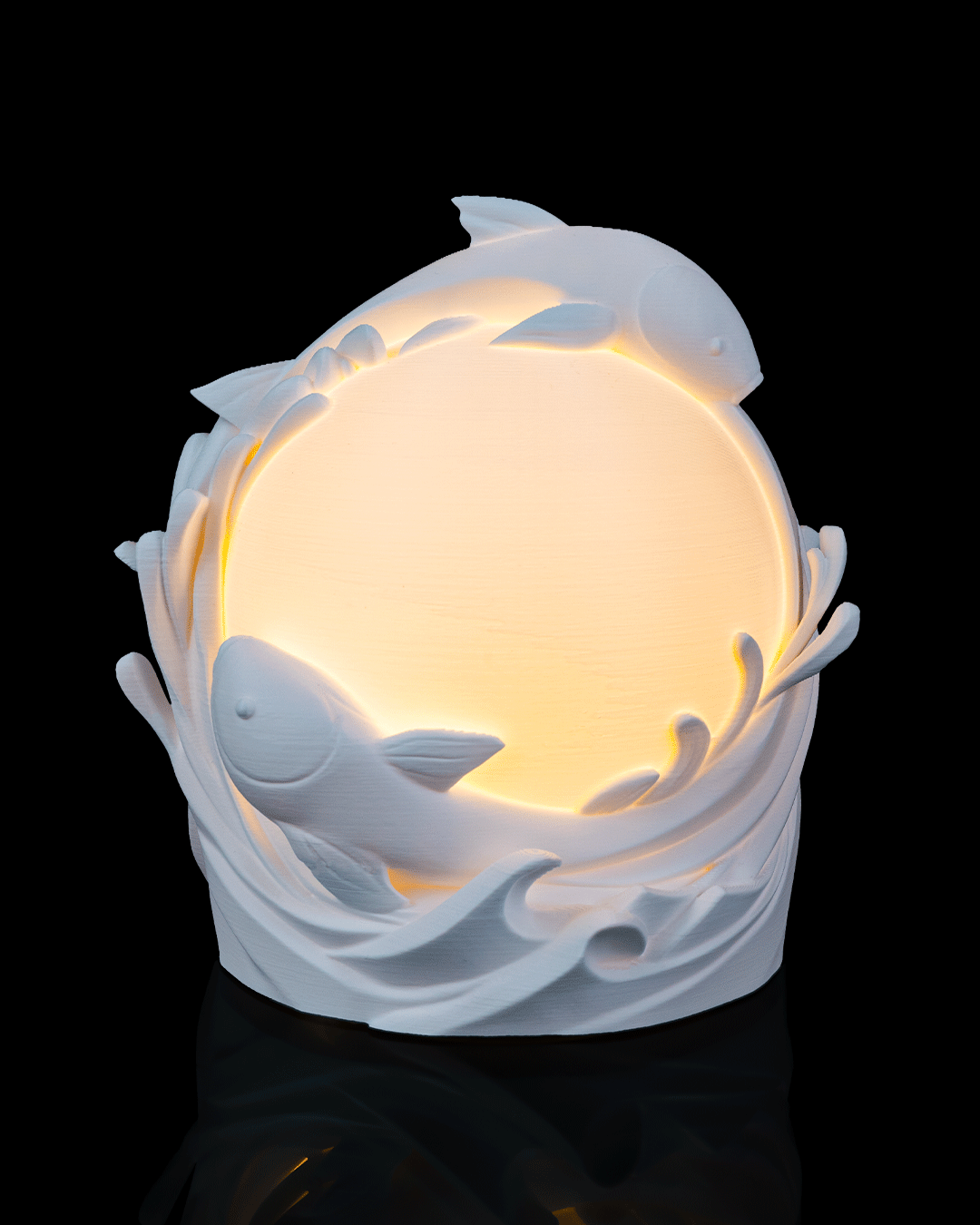 Decorative lamp with dolphins and a glowing interior on a black background