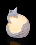 White ceramic fox-shaped night light on a black background