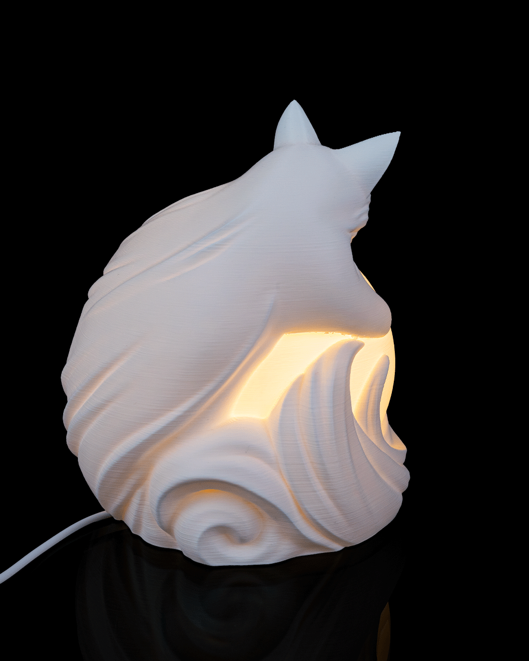 White ceramic cat-shaped lamp with a warm glow on a black background