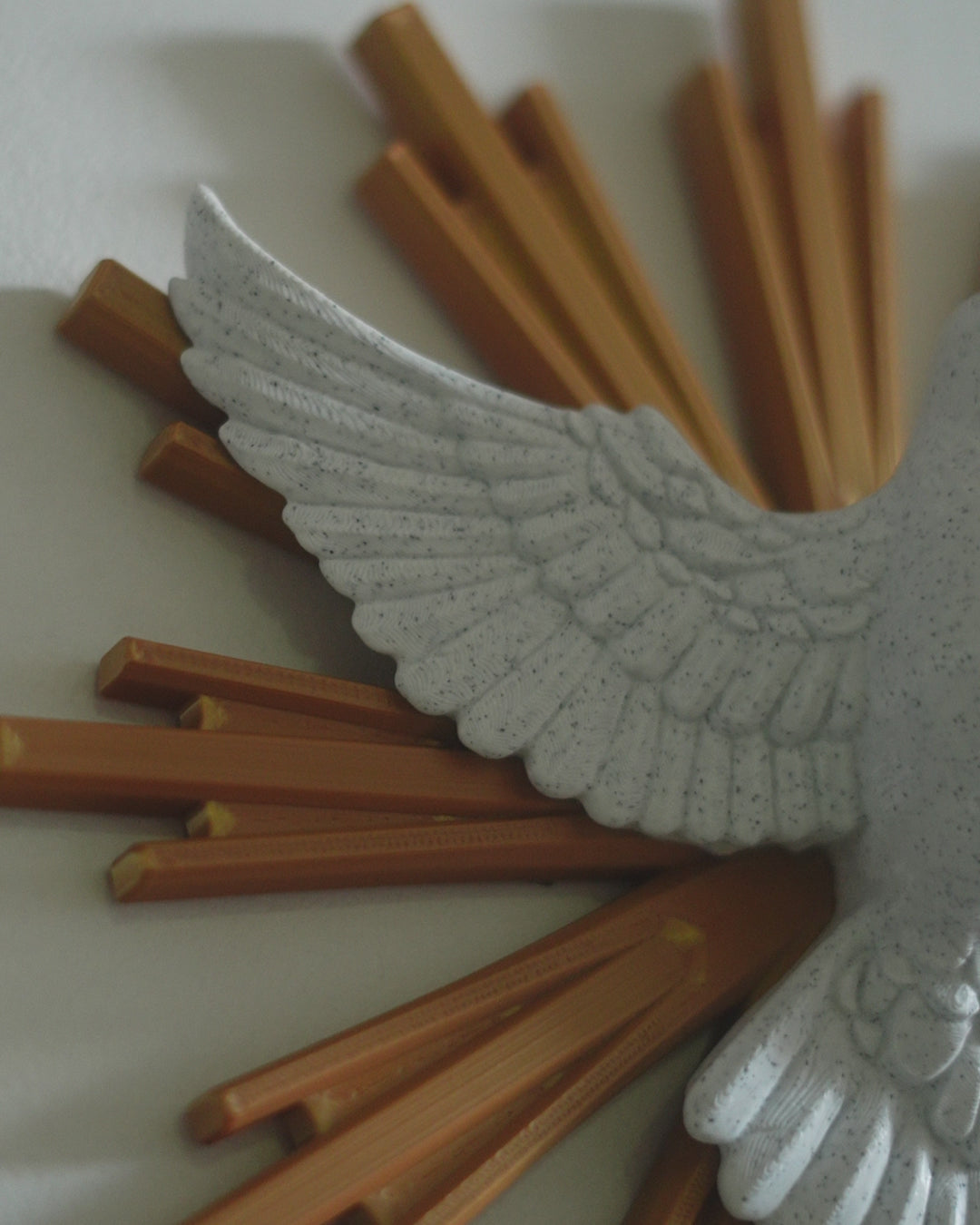 Rotating view of the Dove of Peace wall decoration showing the white stone-effect finish, feather texture, gold rays, and dimensional profile.